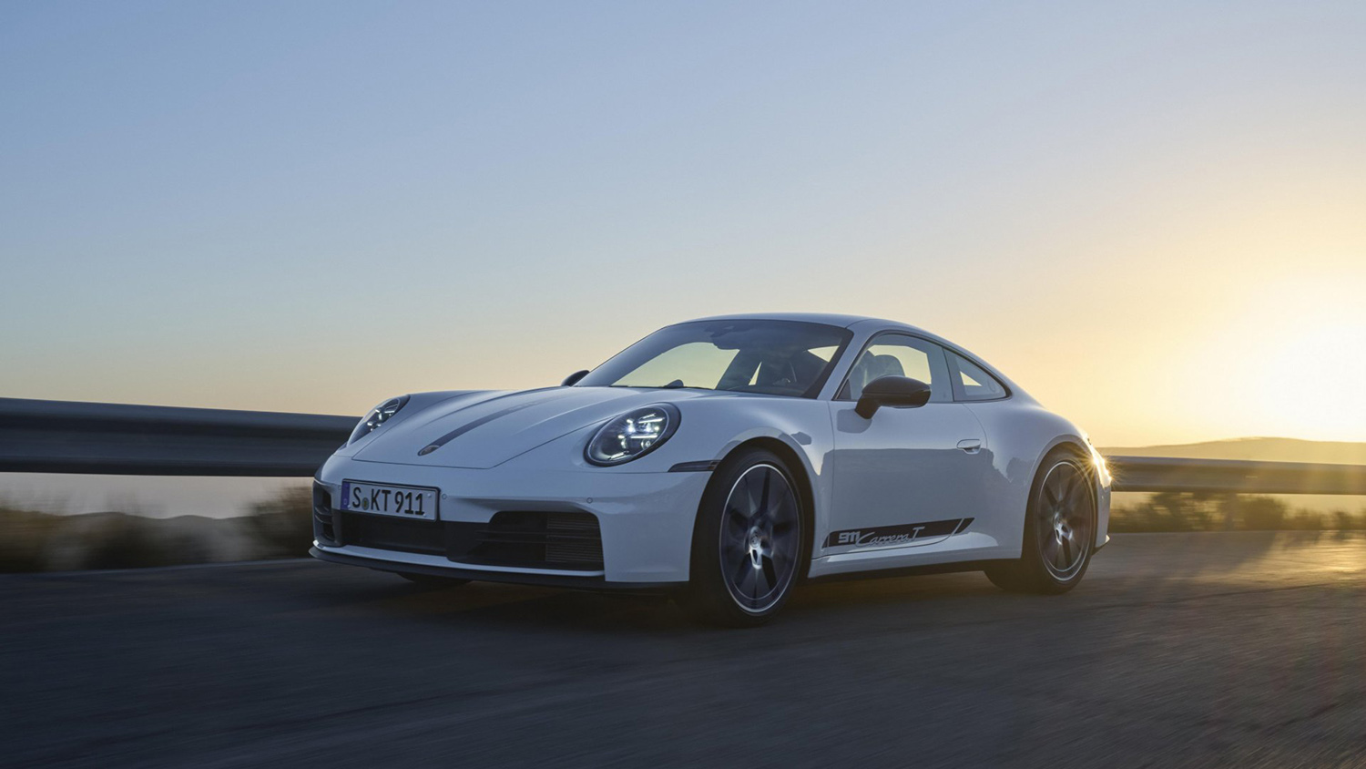 White Porsche 911 Carrera T on road, left front